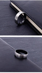Detail of silver brushed titanium ring with black mirror-finish inner surface on slate background