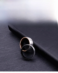 Detail of brushed titanium steel rings with contrast silver and black or gold inner bands