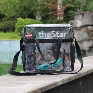 Detail of clear PVC tote bag with mesh side pockets and front zipper pouch for travel