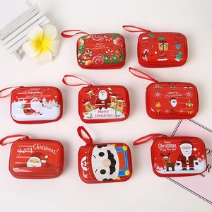 Close-up of red Christmas tinplate coin purses with Santa Claus and reindeer patterns
