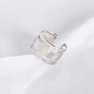 Macro view of a minimalist S925 sterling silver triple-layer hollow line ring on white silk
