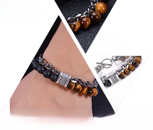 Macro detail of men's tiger eye bead bracelet and stainless steel silver chain with T-bar clasp