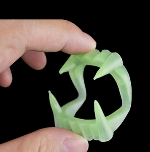 Macro shot of green translucent plastic vampire fangs for Halloween costume parties