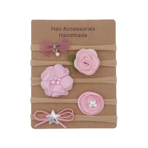 Five-piece pink and beige floral bow baby headbands set on a display card