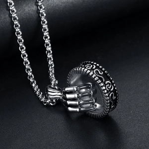 Detailed shot of silver skull hand pendant with rose relief and stainless steel bead chain