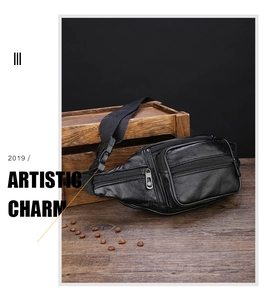 Detail view of black PU leather waist bag with multiple zippers on a vintage wood desk