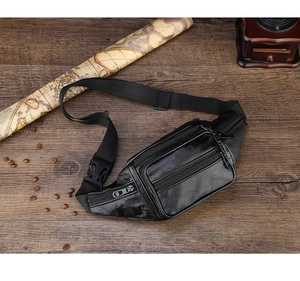 Flat lay of a black PU leather multi-pocket waist bag with metal zippers on a wooden desk