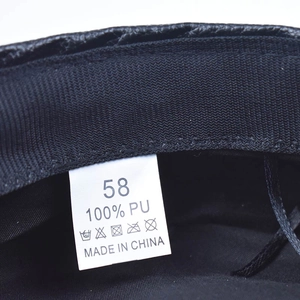 Dettaglio della fodera del berretto con etichetta 100% pelle PU e tag taglia 58
