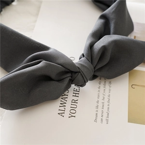 Detail of grey fabric rabbit ear headband showing soft texture and knotted design