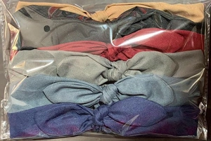 Detailed view of six assorted color knotted headbands in professional transparent packaging
