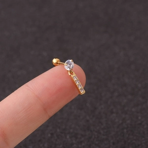 Detail of a gold letter earring with sparkling zircons held between fingers