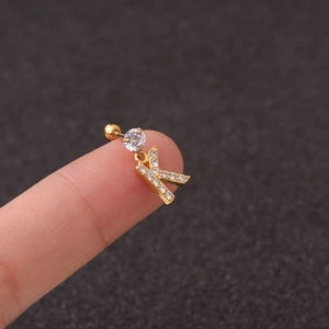 Golden letter K zircon earring with stainless steel screw back shown on finger