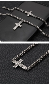 Macro view of vintage silver cross pendant with hammered texture on black leather background
