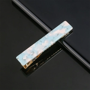 Detailed view of blue and white marble acrylic hair clip with golden metal clip