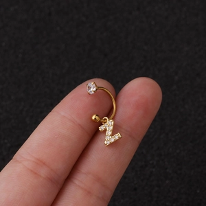 Vue macro détaillée d'une boucle d'oreille en C dorée avec pendentif lettre Z en zircon