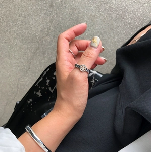 Detail of silver smiley face ring and polished cuff bracelet on a model hand