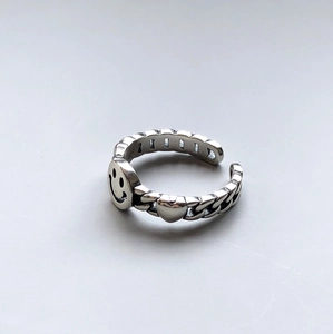 Close-up of vintage 925 silver smiley face open ring with rustic engraved details