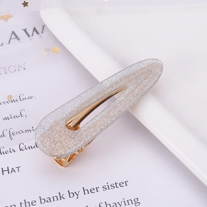 Detailed macro view of silver glitter hair clip with golden metal base for women