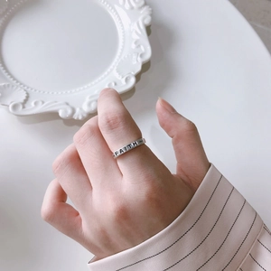 Detail shot of a silver 925 sterling silver ring with FAITH engraving on model's finger