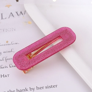 Close-up of pink glitter rectangular hair clip with gold metal duckbill base