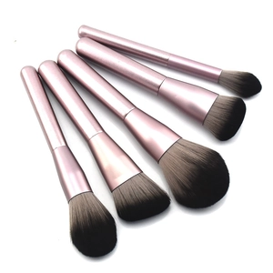 Five professional makeup brushes with pink metal handles and soft gradient grey bristles