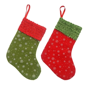 Close-up of red and green fabric Christmas stockings with snowflake patterns on white