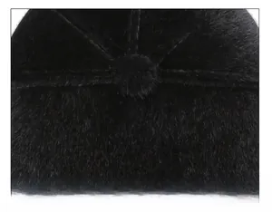 Detailed view of plush black cap with multi-panel stitching and central top button