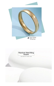 Detail of 4mm golden titanium steel ring on white pebbles with smooth mirror finish