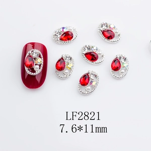 Macro view of silver braided nail jewelry with red drop crystal and side pearls