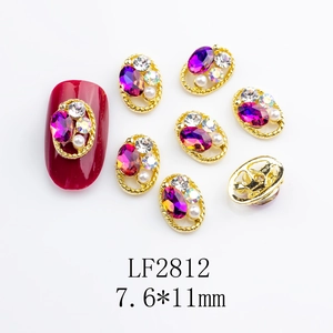 Detail of oval purple gemstone nail charms with twisted gold frames and pearls