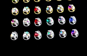 Close-up of alloy nail charms with colorful K9 oval crystals and twisted metal borders