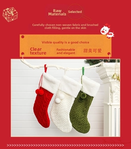 Détail de chaussettes de Noël en tricot rouge, blanc et vert avec pompons en peluche