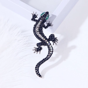 Exquisite gecko brooch with deep blue rhinestones and iridescent accents on white feather