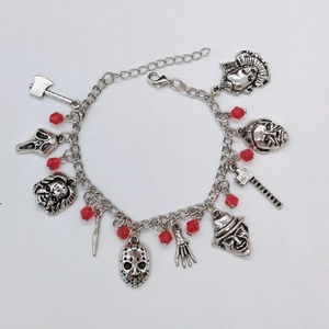 Détail du bracelet à breloques de films d'horreur argenté avec masques et perles rouges