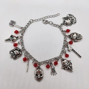 Détail du bracelet horreur argenté avec pendentifs masques de terreur et perles rouges