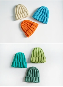 Detail shot of knitted beanies in ivory, sky blue, orange, and green autumn colors