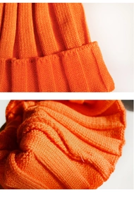 Macro view of the orange ribbed knit fabric detail showing thick texture and pattern
