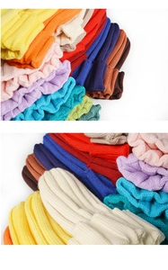 Macro shot showing diverse vibrant colors and thick knit texture of the beanies