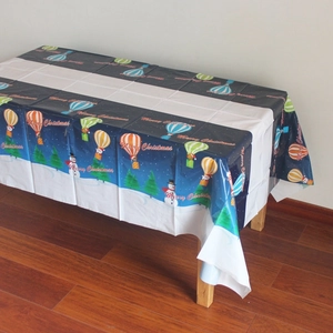 Détail de nappe de Noël avec bonhommes de neige, sapins et montgolfières sur fond bleu