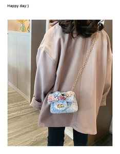 Dettaglio della borsa a tracolla in tweed blu per bambina con fiori e catena d'oro