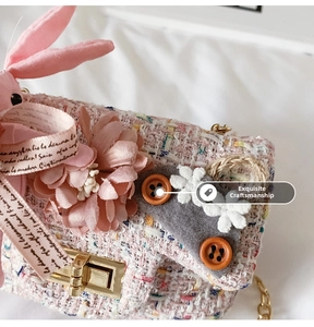 Dettaglio borsa in tweed rosa per bambina con fiori in tessuto, orecchie di coniglio e fibbia