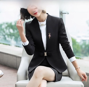 Elegante spilla ballerina con gonna rosa sul bavero di un abito nero da donna