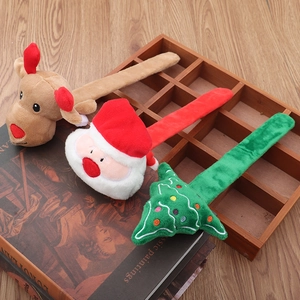 Classic Christmas plush slap bracelets featuring Santa, reindeer and tree on a wooden shelf