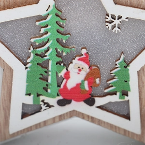 Detailed close-up of a lit wooden star ornament with Santa and glittery Christmas trees