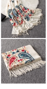 Macro shot of ethnic paisley embroidery and tassel edge on beige cashmere shawl
