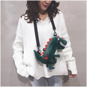 Cute green plush dinosaur crossbody bag with adjustable strap worn by model
