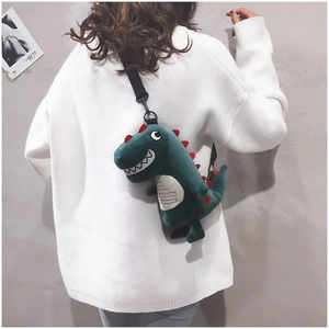 Green plush dinosaur crossbody bag with adjustable black shoulder strap shown on model