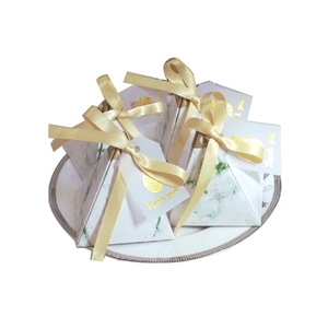 Detail of pyramid marble gift boxes with gold pineapple foil and thank you tags