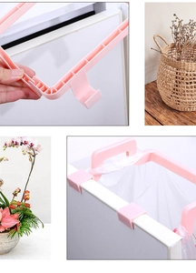 Detailed view of pink plastic trash bag holder showing the hook and kitchen cabinet setup