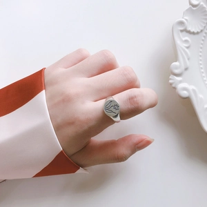 Macro shot of a minimalist 925 sterling silver oval signet ring with floral engraving